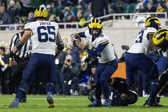Zak Zinter (65), J.J. McCarthy (9), and LaDarius Henderson (73)