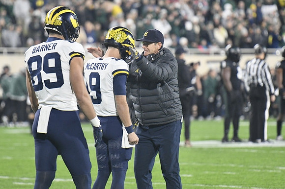AJ Barner (89), J.J. McCarthy (9), and Jim Harbaugh