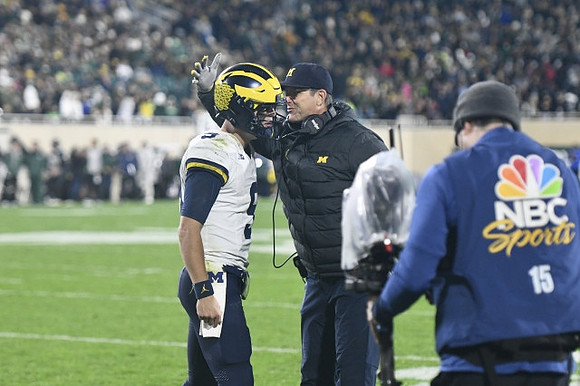 J.J. McCarthy (9) and Jim Harbaugh