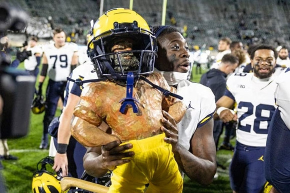 Jeffrey Persi (79), Paul Bunyan Trophy, Rod Moore (9), and Quinten Johnson (28)