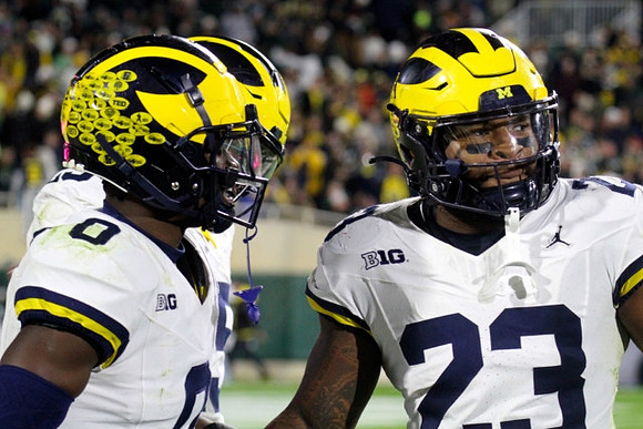 Mike Sainristil (0) and Michael Barrett (23)