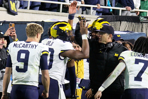 J.J. McCarthy (9), Alex Orji (10), Jim Harbaugh, and Donovan Edwards (7)