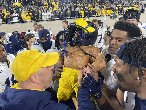 Will Johnson (2), Paul Bunyan Trophy, and Michigan Team