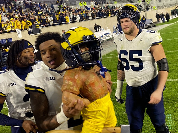 Will Johnson (2), Paul Bunyan Trophy, and Zak Zinter (65)