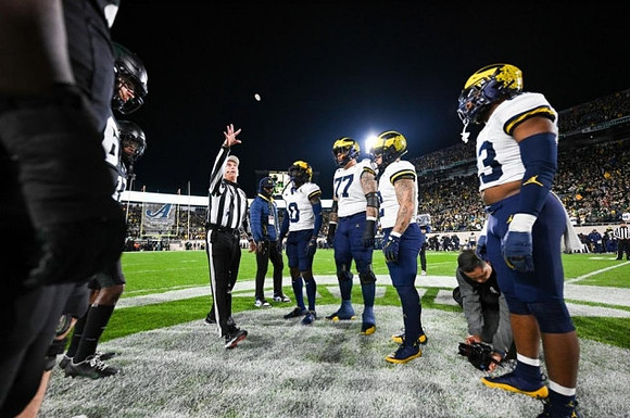Mike Sainristil (0), Trevor Keegan (77), Blake Corum (2), and Michael Barrett (23)