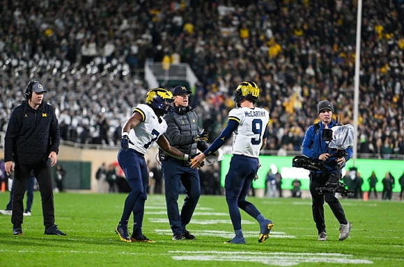Donovan Edwards (7), Jim Harbaugh, and Darrius Clemons (0)