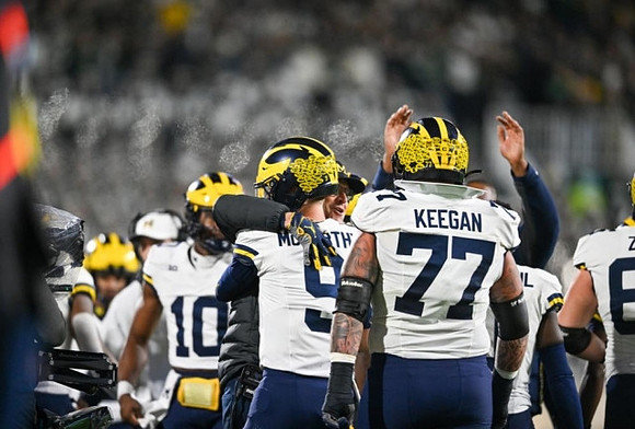 Alex Orji (10), J.J. McCarthy (9), and Trevor Keegan (77)