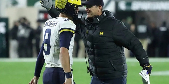 J.J. McCarthy (9) and Jim Harbaugh