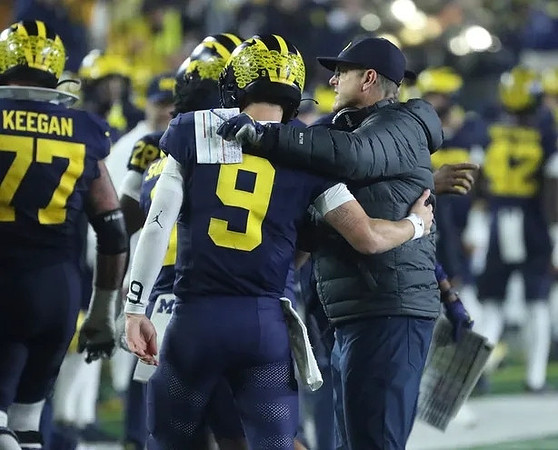 Trevor Keegan (77), J.J. McCarthy (9), and Jim Harbaugh