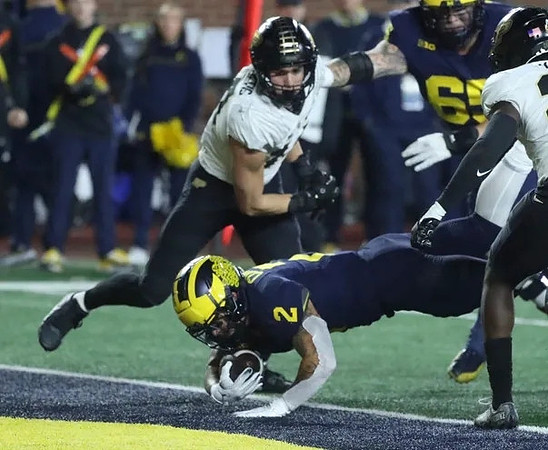 Blake Corum (2) and Zak Zinter (65)
