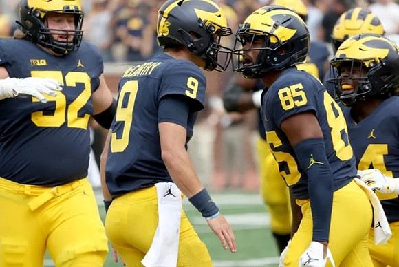 Karsen Barnhart (52), J.J. McCarthy (9), Daylen Baldwin (85), and Leon Franklin (34)