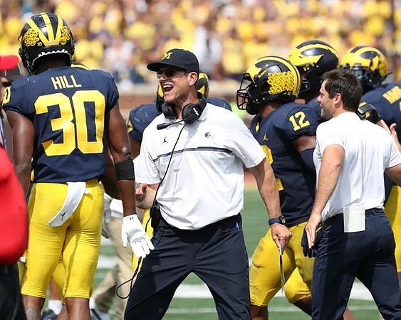 Daxton Hill (30), Jim Harbaugh, and Josh Ross (12)