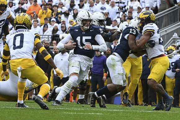 Mike Sainristil (0) and Junior Colson (25)