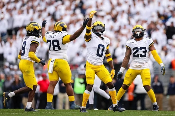 Rod Moore (9), Kenneth Grant (78), Mike Sainristil (0), and Michael Barrett (23)