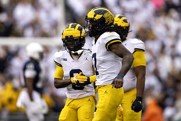 Mike Sainristil (0) and Makari Paige (7)