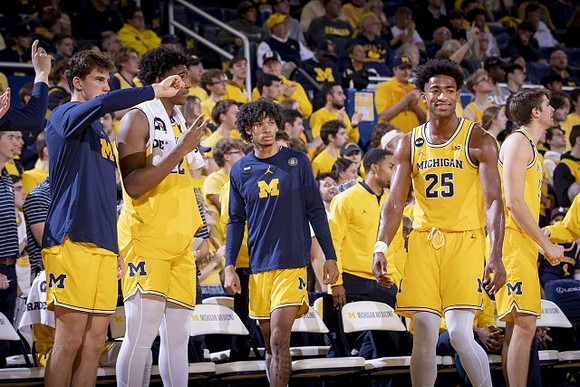 Jace Howard (25) and Michigan Team