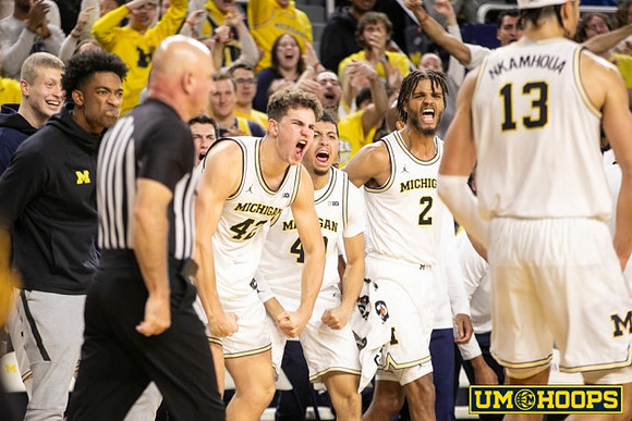 Olivier Nkamhoua (13) and Michigan Team