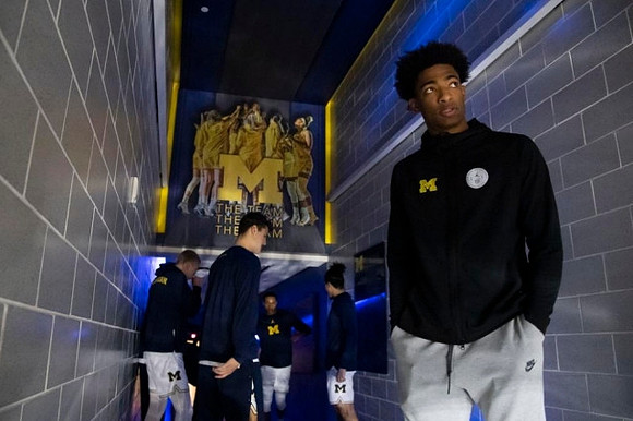 Jace Howard (25) and Michigan Team