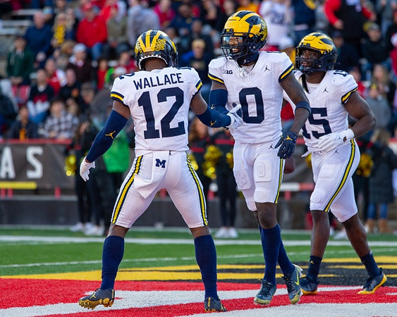 Josh Wallace (12), Mike Sainristil (0), and Ernest Hausmann (15)