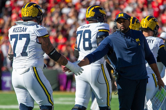 Trevor Keegan (77), Myles Hinton (78), Sherrone Moore, and J.J. McCarthy (9)