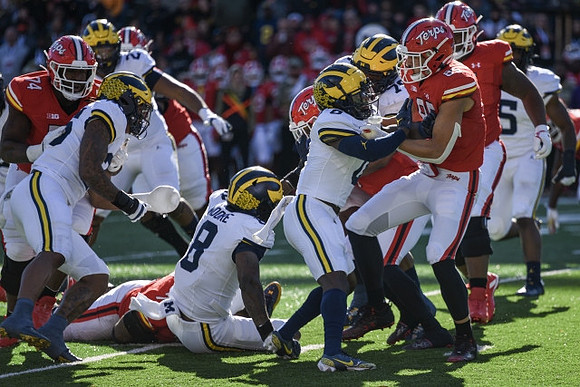 Josaiah Stewart (5), Derrick Moore (8), and Mike Sainristil (0)