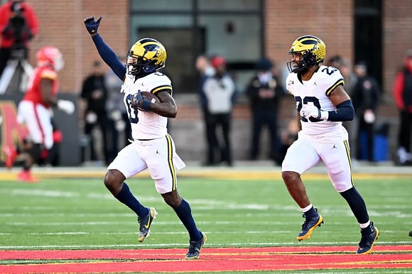 Mike Sainristil (0) and Michael Barrett (23)