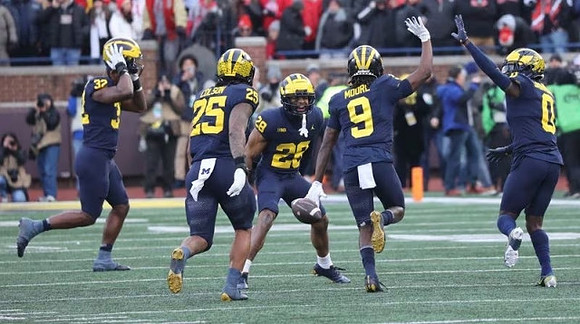 Jaylen Harrell (32), Junior Colson (25), Quinten Johnson (28), Rod Moore (9), and Mike Sainristil (0)