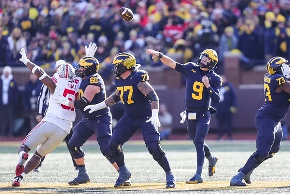 Drake Nugent (60), Trevor Keegan (77), J.J. McCarthy (9), and LaDarius Henderson (73)