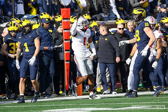 Roman Wilson (1), Sherrone Moore, and Colston Loveland (18)