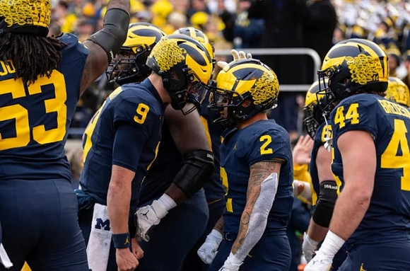 Trente Jones (53), J.J. McCarthy (9), Blake Corum (2), and Max Bredeson (44)