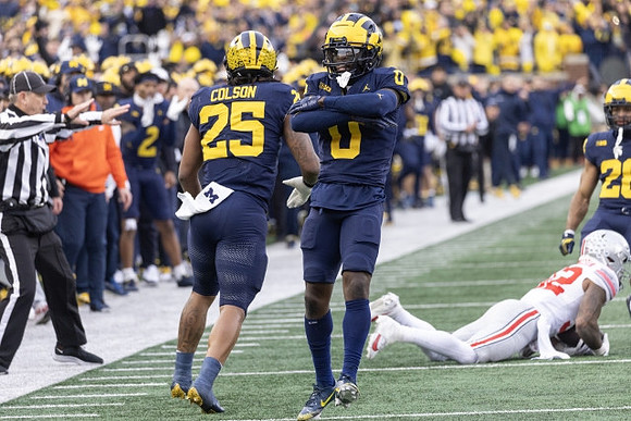 Junior Colson (25), Mike Sainristil (0), and Quinten Johnson (28)