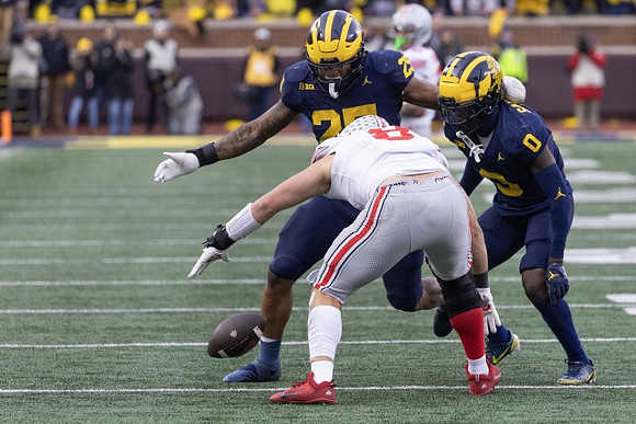 Junior Colson (25) and Mike Sainristil (0)