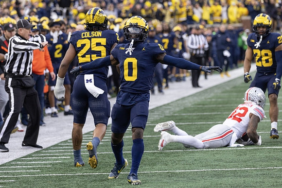 Junior Colson (25), Mike Sainristil (0), and Quinten Johnson (28)