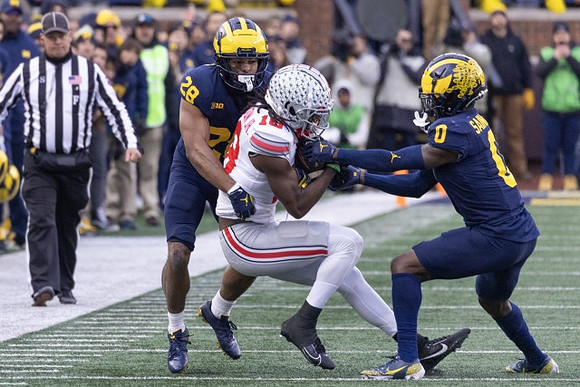 Quinten Johnson (28) and Mike Sainristil (0)