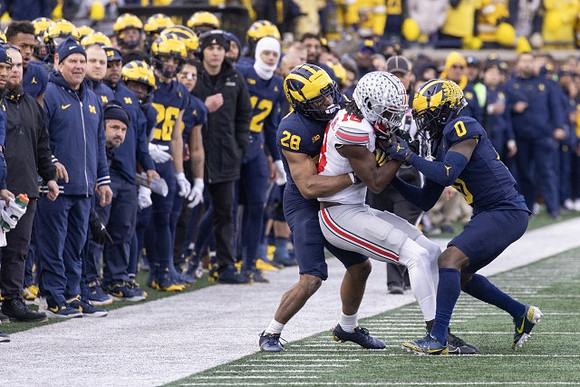 Quinten Johnson (28) and Mike Sainristil (0)