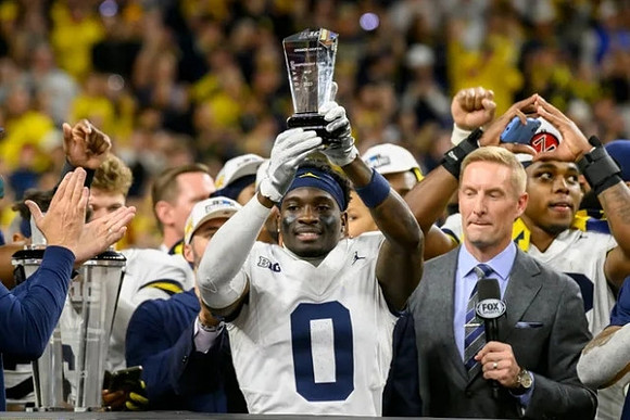 Mike Sainristil (0) and Big Ten Championship MVP Trophy