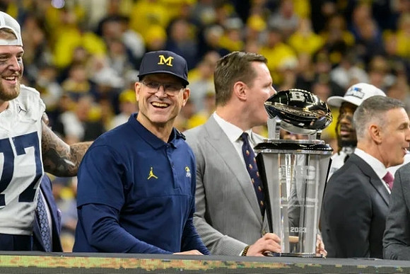 Trevor Keegan (77), Jim Harbaugh, and Big Ten Championship Trophy