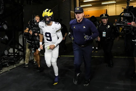 J.J. McCarthy (9) and Jim Harbaugh