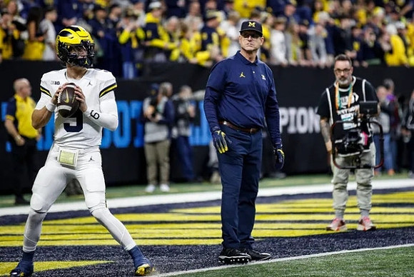 J.J. McCarthy (9) and Jim Harbaugh
