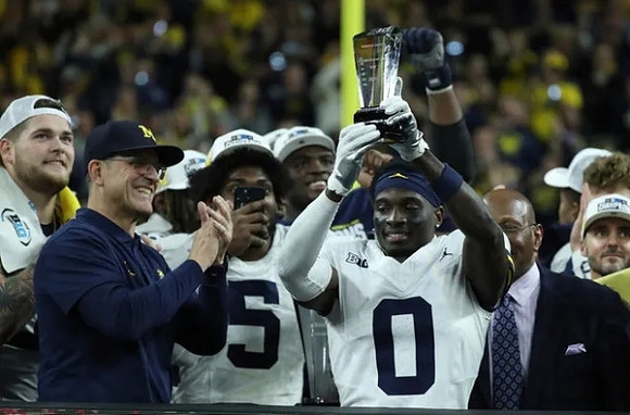 Zak Zinter (65), Jim Harbaugh, Josaiah Stewart (5), Mike Sainristil (0), and Big Ten Championship MVP Trophy