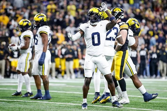 Rayshaun Benny (26), Mike Sainristil (0), and Michael Barrett (23)