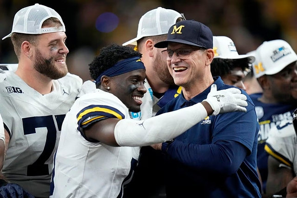 Trevor Keegan (77), Mike Sainristil (0), and Jim Harbaugh