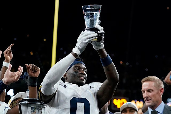 Mike Sainristil (0) and Big Ten Championship MVP Trophy