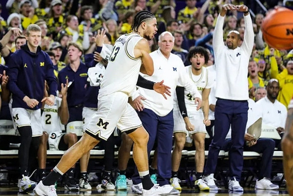 Olivier Nkamhoua (13) and Michigan Team
