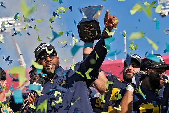Sherrone Moore, Giovanni El-Hadi (58), and ReliaQuest Bowl Trophy