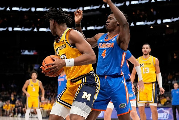 Nimari Burnett (4), Tarris Reed Jr. (32), and Olivier Nkamhoua (13)