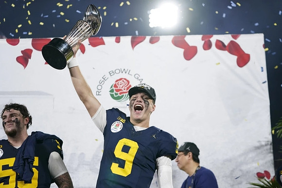 Mason Graham (55), J.J. McCarthy (9), and UofM President Santa Ono