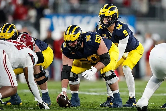 Drake Nugent (60) and J.J. McCarthy (9)