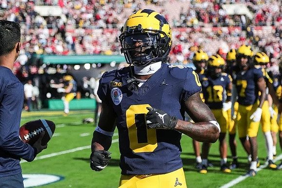 Mike Sainristil (0) and Michigan Team