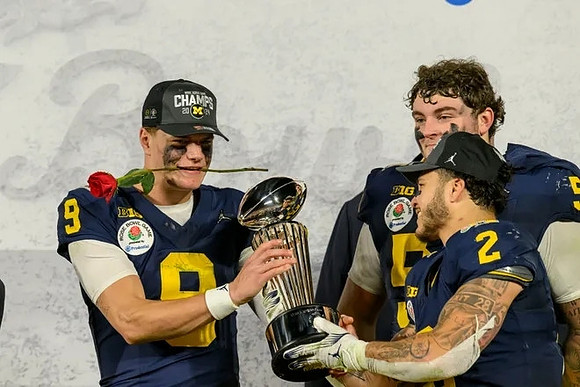 J.J. McCarthy (9), Blake Corum (2), Nathan Efobi (55), and Rose Bowl Trophy